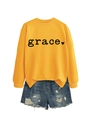 Detail of yellow sweatshirt with grace print and ribbed cuffs paired with denim shorts - Yellow Sweatshirt (Black Font)