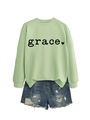 Close-up of light green sweatshirt with grace heart print and denim shorts - Olive Green Sweatshirt (Black Font)