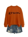 Detail of orange crewneck sweatshirt with heart print and side slit hem design - Burnt Orange (Black Font)