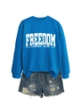 Detail of bright blue long sleeve sweatshirt with white FREEDOM print and denim shorts - Lake Blue Sweatshirt (White Font)