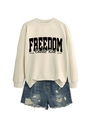 Detail of beige sweatshirt with Freedom print paired with distressed denim shorts - Sand Sweatshirt (Black Font)