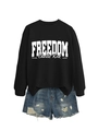 Detail of black long-sleeve sweatshirt with white Freedom print and blue ripped denim shorts - Black Sweatshirt (White Font)