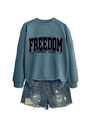 Close-up of Charlie Kirk Freedom print on blue sweatshirt with ripped denim shorts - Blue Sweatshirt (Black Font)