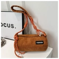 Detail of brown corduroy cylinder bag featuring fashion label and braided rope strap - Brown