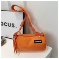 Close-up of bright orange corduroy cylinder bag featuring a woven rope shoulder strap - Orange