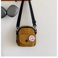 Detailed macro of vintage canvas mini crossbody bag with cartoon bunny patch and clasp - Brown