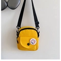 Detail of yellow canvas mini bag featuring a cartoon badge and adjustable strap - Yellow