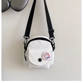 Detail of white canvas crossbody bag featuring adjustable black strap and cute rabbit badge - White