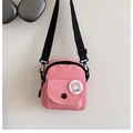 Detailed close-up of pink canvas shoulder bag with cartoon rabbit pin and front pocket - Pink