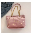 Rosa Samt-Tragetasche mit goldenen Sonnen-Nieten und Kettenriemen neben Jeansjacke - Rosa