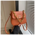 Detail der orangen Satteltasche mit goldener D-Schnalle und dekorativer Gliederkette - Orange
