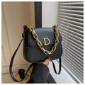 Detail der schwarzen Satteltasche mit goldener Kette und metallischem D-Logo-Akzent - Schwarz