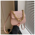Vue détaillée du sac selle en cuir rose avec logo D doré et bandoulière chaîne - Rose