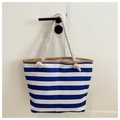 Detalle del bolso tote de lona a rayas azules y blancas con ribete y asa de cuerda - Azul