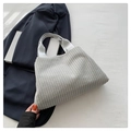 Sac cabas en velours côtelé gris clair avec texture rayée sur un blazer marine - Gris