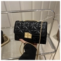 Détail du fermoir tournant doré sur un petit sac bandoulière noir à losanges matelassés - Style Serrure Carrée (1602) / Noir