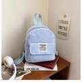 Detail of light blue corduroy mini backpack with zipper and woven square brand label - Grey Blue