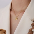 Elegante goldene Titanstahlkette mit unregelmäßigem Zirkonia-Anhänger an einem Modell - Oktogramm Unregelmäßiges Rundes Etikett (P280) / Gold