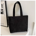 Detalle de la textura del bolso tote de pana negra con patrón de nervaduras verticales - Negro