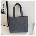 Bolso tote de pana gris oscuro con asas dobles en un ambiente interior minimalista - Gris