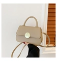 Elegant beige crossbody bag featuring a round textured gold buckle and top handle - Khaki