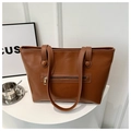 Minimalist dark brown leather tote bag with front zipper pocket on a white pedestal - Brown
