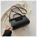 Black suede and faux leather crossbody bag with gold hardware on beige blazer - Black