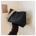 Black leather bucket bag with white stitching and colorful geometric woven strap - Black
