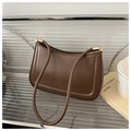 Detail view of dark coffee baguette bag featuring golden square hardware and thin straps - Brown
