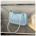 Detail of light blue minimalist shoulder bag with gold hardware on a lifestyle setup - Blue