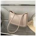 Detail of minimalist beige leather underarm bag with U-shaped stitching and gold hardware - Khaki