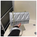 Detailed shot of silver quilted crossbody bag with golden chain strap and leather pad - Silver