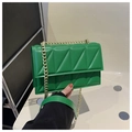 Detail of vibrant green quilted crossbody bag with gold chain strap and stitching - Green
