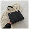 Black quilted tote bag featuring geometric patterns and a golden chain shoulder strap - Black