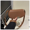 Close-up of brown saddle bag with matte PU leather texture and vertical gold clasp - Brown