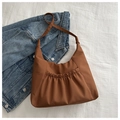 Detailed view of the dark brown pleated nylon crossbody bag on white fabric background - Brown