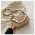 Close-up of beige saddle bag featuring pearl and silver heart chain strap detail - Khaki