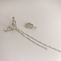 Pendientes asimétricos de metal líquido con finas cadenas de plata en fondo gris - Oro Blanco
