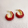 Modern red enamel C-shaped earrings with gold metal edges in a 45-degree studio view - Red