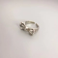 Detailansicht eines silbernen Schleifenrings mit eleganter, gedrehter Textur - Silberner Schleifen-Stil