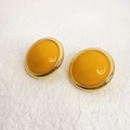 Pendientes retro redondos dorados con resina amarilla sobre fondo blanco texturizado - Amarillo