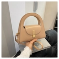 Detail of beige handbag with large circular handle, gold metal clasp and thin strap - Khaki