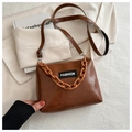 Detail of a brown gloss PU leather crossbody bag with chain handle and fashion label - Brown