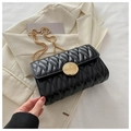 Quilted black chain crossbody bag with golden round buckle on white fabric - Black