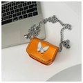 Vue détaillée du mini sac orange métallisé avec chaîne argentée et fermoir papillon - Orange