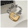 Detailed shot of golden mini crossbody bag with butterfly clasp and silver chain strap - Gold