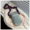 Detail view of mint corduroy bag with purple pleated strap and orange snap button - Light Green