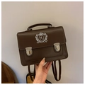Detail einer braunen Vintage-Leder-Umhängetasche mit weißem Wappen-Stickerei-Logo - Braun