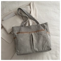 Dettaglio della borsa tote in velluto a coste grigio con tasche e finiture a contrasto - Grigio