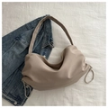 Borsa tote beige minimalista in nylon con coulisse e tracolla larga su sfondo di tessuto - Cachi